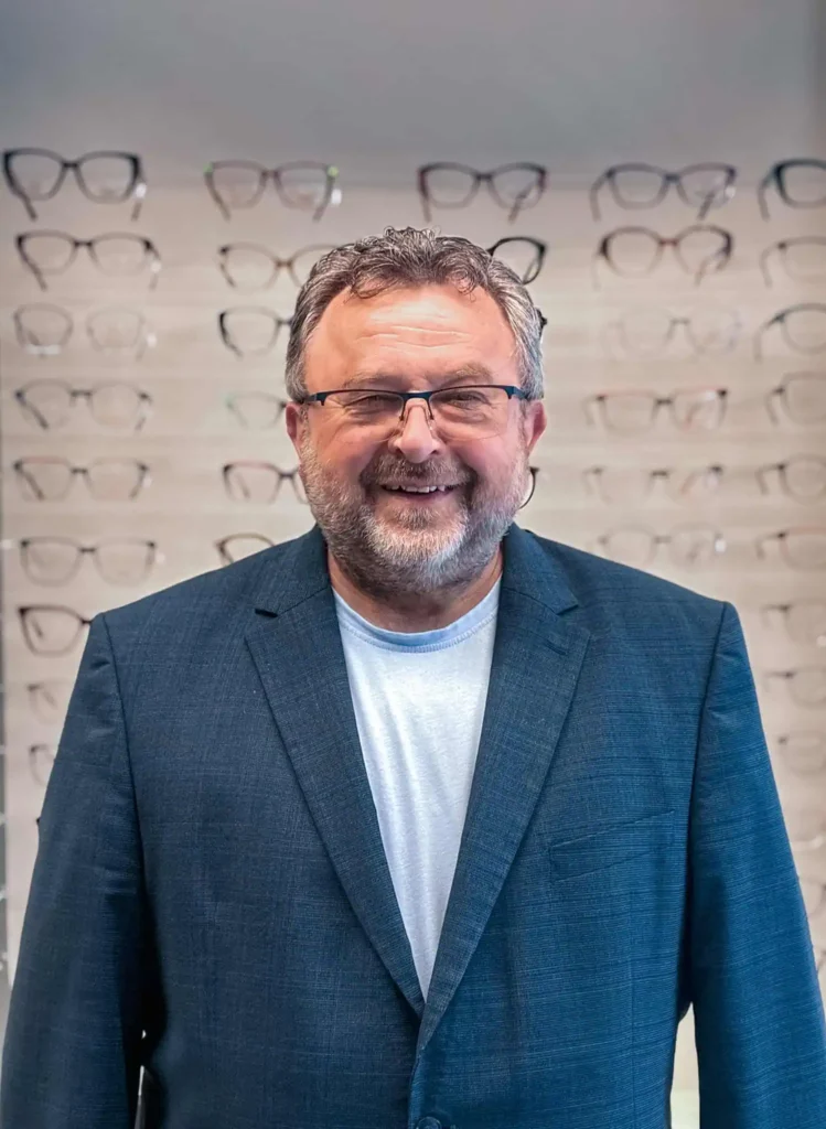 Lächelnder Mann im Brillengeschäft mit Brille