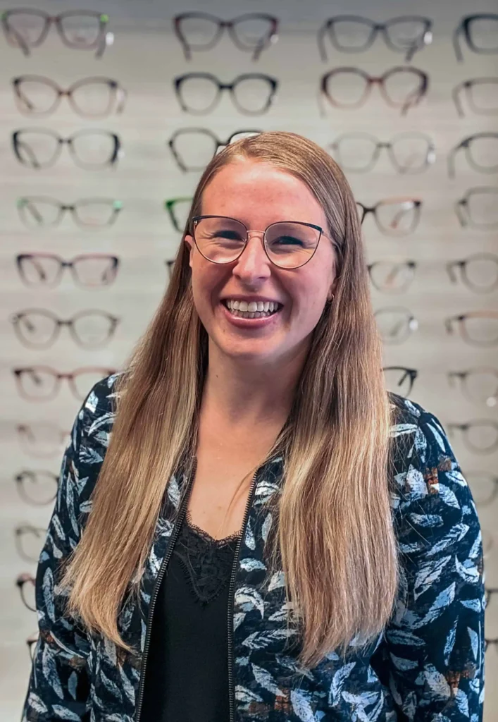 Lächelnde Frau mit Brille im Optikergeschäft