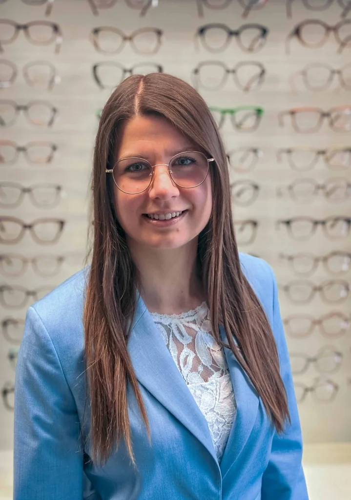 Lächelnde Frau mit Brille im Optikgeschäft